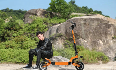 a man sitting on a rock next to an JGH X5 Ultra off-road electric scooter