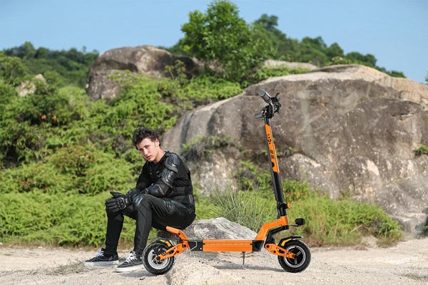 a man sitting on a rock next to an JGH X5 Ultra off-road electric scooter