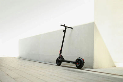 an electric scooter parked next to a wall