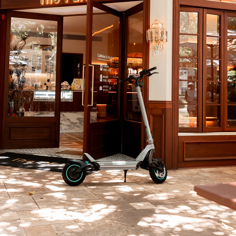 a JGH X3 e-scooter parked in front of a store